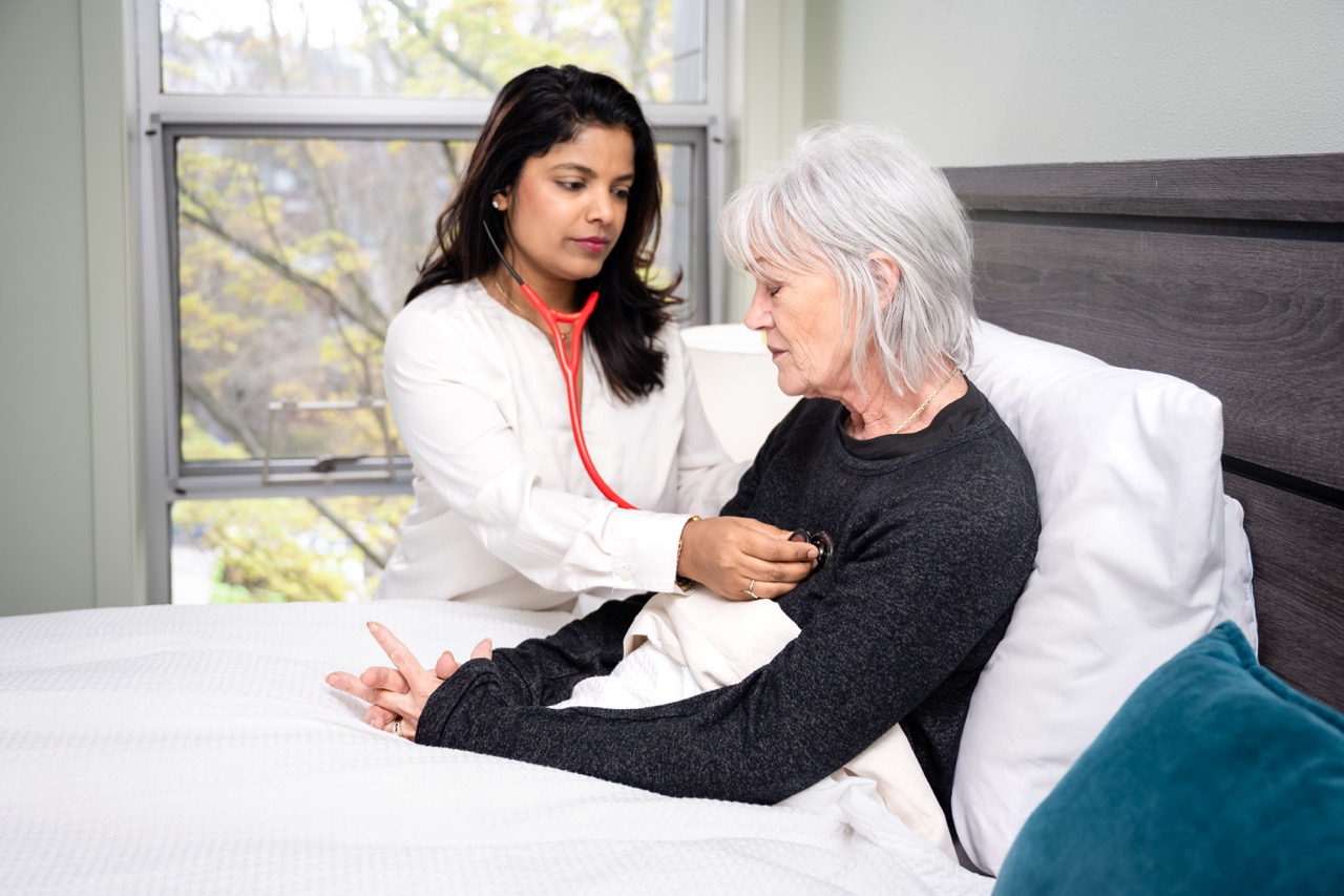 Dr. Neha listening to a patient at bedside
